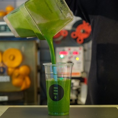 A Super Green smoothie, made with banana, chia seeds, spinach, supergreens and coconut milk being poured into a Juicery Dublin cup at Jay Kays Cafe in Dublin city centre